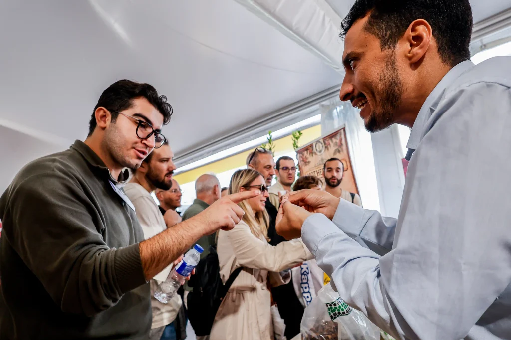 Abdulrazzaq Al-Khishani explaining Yemeni coffee beans to a visitor at the FAO Global Exhibition 2026 in Rome